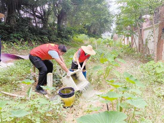 工作人員清理環(huán)境積水。