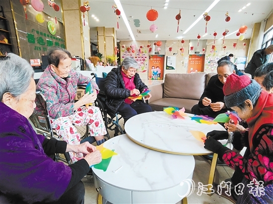 老人們圍坐在桌前，專注地制作小風車。