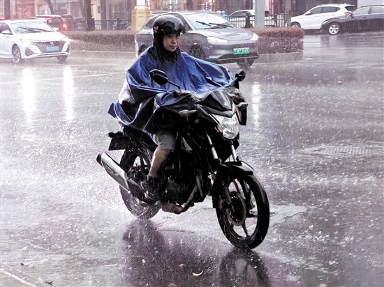 昨天，在市區(qū)東華一路，一位市民騎著摩托車在雨中前行。