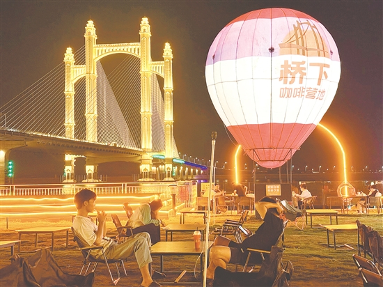 夜幕降臨，潭江兩岸燈火闌珊，市民、游客在“橋下咖啡營地”品咖啡、賞夜景，享受愜意時光。
