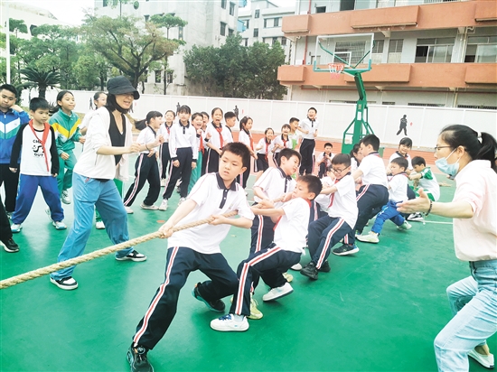 雙方隊(duì)員緊握長繩，齊心協(xié)力，鼓足勁拼命往后拉，全力以赴為班級榮譽(yù)而戰(zhàn)。
