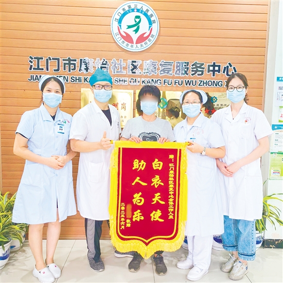 李明給康復(fù)中心醫(yī)護人員送上錦旗。
