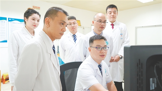謝志駿（左四）和同事討論影像報(bào)告。